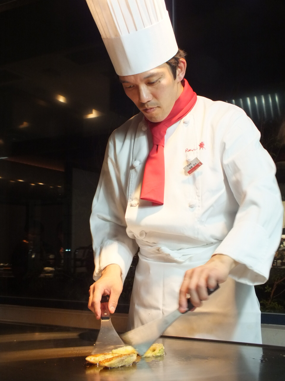鉄板で料理を仕上げるシェフ